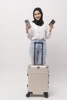 A young muslim woman tourist with baggage  on white background photo