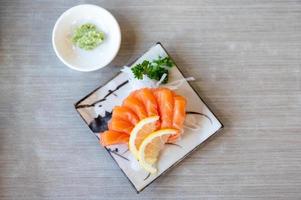 salmón sashimi en japonés estilo Fresco servir en blanco lámina. foto