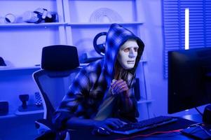 A Hacker is using laptop computer to steal data in the night photo