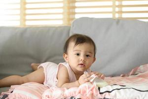 A baby girl is drinking milk bottle, family, child, childhood and parenthood concept photo