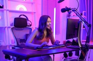 Young Asian Pretty woman Pro Gamer have live streaming , singing  and chatting  with her fans  at home photo