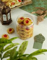 Selective focus of thumbprint cookies filled with strawberry jam and grated cheese. Served for eid al fitr. photo