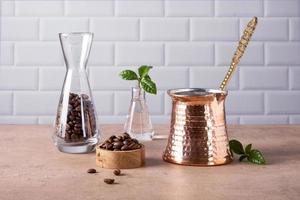 Composition of a Turkish coffee pot cezve, coffee beans and a branch of a coffee tree photo