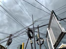 lightning electric pole with unorganized wires. electric high voltage danger. electrical pole silhouette. photo