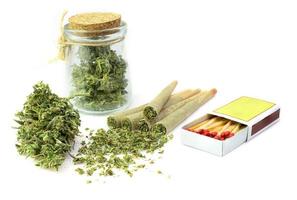 Pre-Roll cannabis joint with cannabis buds in a clear glass jar on the white background photo