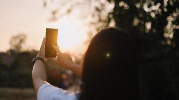 cerca arriba mujer mano sostener utilizando inteligente teléfono en al aire libre parque calle antecedentes. Copiar espacio de tecnología negocio y viaje fiesta concepto. Clásico tono filtrar efecto color estilo. foto