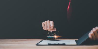 Businessman validates and manages business documents and agreements,signing a business contract approval,joint venture agreement,contract documents confirmation,approval stamp ,stamping in contract photo