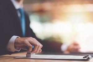 Businessman validates and manages business documents and agreements,signing a business contract approval,joint venture agreement,contract documents confirmation,approval stamp ,stamping in contract photo