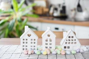 Key to house of cozy home with Easter decor with rabbit and eggs on table of kitchen. Building, design, project, moving to new house, mortgage, insurance, rent and purchase real estate photo