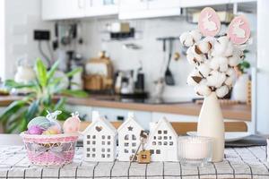 Key to house of cozy home with Easter decor with rabbit and eggs on table of kitchen. Building, design, project, moving to new house, mortgage, insurance, rent and purchase real estate photo