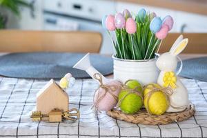 Key to house of cozy home with Easter decor with rabbit and eggs on table of kitchen. Building, design, project, moving to new house, mortgage, insurance, rent and purchase real estate photo