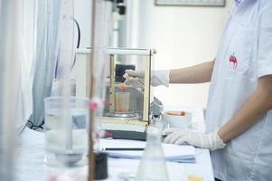 Asian female specialist in quality control lab examining tomato ingredient food in research lab, food industry photo