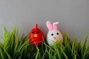 Easter holiday, a handmade egg made by a child in the form of a rabbit and chicken against a grey background photo