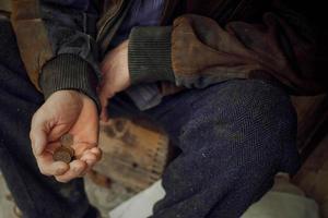 The hand of an elderly man holding Ukrainian money. Poverty, donations, unemployment. photo