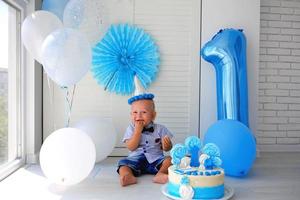 Little boy celebrate birthday. 1 year old, decorations, 1 year cake, balloons. photo