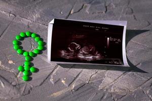 Gender symbol made from green pills or tablets, dummy  and ultrasound picture photo