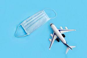 Plane model and face medical mask on a blue background . photo