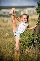 A flexible child, doing gymnastics exercises. Sports, learning, fitness, stretching, yoga, active lifestyle concepts photo