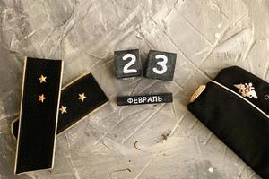 Navy pilot and shoulder straps with two stars and a wooden calendar with the date February 23. Fatherland defender day. photo