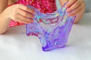 Hand holding homemade toy called Slime, kids having fun and being creative by science experiment. photo