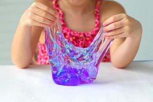 Hand holding homemade toy called Slime, kids having fun and being creative by science experiment. photo