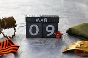 Flask, Gergiev ribbon, cap, army belt with the image of a sickle ,  hammer and wooden calendar with the date May 09. photo