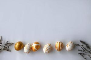 Top view Easter eggs painted with gold paint in various patterns on the sides of lavender. photo