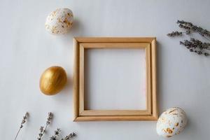 Easter eggs on a gold  and wooden frame background on a white background. photo