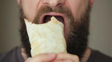 Bearded man eats kebab - unhealthy food video