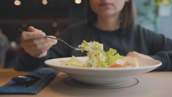 vrouw aan het eten Caesar salade in een cafe video