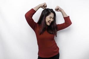 A young Asian woman with a happy successful expression wearing red top isolated by white background photo