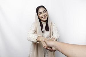 Portrait of a young beautiful Asian Muslim woman wearing a headscarf gesturing Eid Mubarak greeting photo