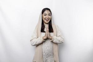 Portrait of a young beautiful Asian Muslim woman wearing a headscarf gesturing Eid Mubarak greeting photo