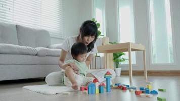 Happy Asia mother play and learn toy blocks with the little girl. Funny family is happy and excited in the house. Mother and daughter having fun spending time together. Holiday, Activity, development video