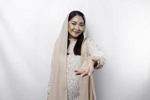 Portrait of a young beautiful Asian Muslim woman wearing a headscarf gesturing Eid Mubarak greeting photo