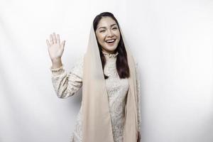 Portrait of a young beautiful Asian Muslim woman wearing a headscarf gesturing Eid Mubarak greeting photo