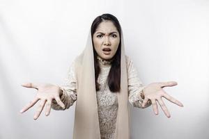 A portrait of an Asian Muslim woman wearing a headscarf isolated by white background looks depressed photo