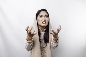 un retrato de un asiático musulmán mujer vistiendo un Pañuelo aislado por blanco antecedentes mira Deprimido foto