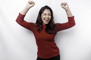 A young Asian woman with a happy successful expression wearing red top isolated by white background photo