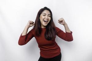 A young Asian woman with a happy successful expression wearing red top isolated by white background photo