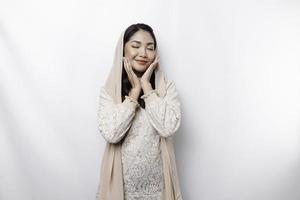 joven asiático musulmán mujer vistiendo Pañuelo sonriente a el cámara, aislado por blanco antecedentes foto