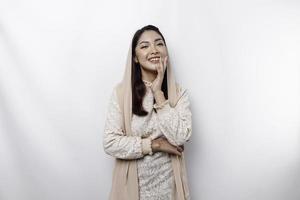 Young Asian Muslim woman wearing headscarf smiling to the camera, isolated by white background photo