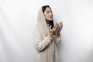 Religious beautiful Asian Muslim girl wearing a headscarf praying to God. photo