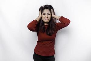 A portrait of an Asian woman wearing a red top isolated by white background looks depressed photo