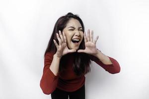 Young beautiful woman wearing a red top shouting and screaming loud with a hand on her mouth. communication concept. photo