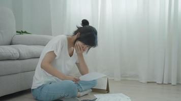 Stressed and headache asian woman with large bills or invoices no money to pay to expenses and credit card debt. shortage, Financial problems, mortgage, loan, bankruptcy, bankrupt, poor, empty wallet video