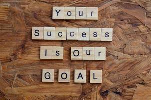 your success is our goal text on wooden square, business motivation quotes photo