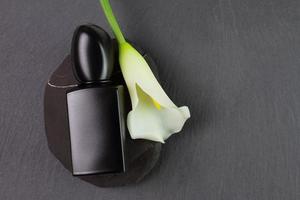 Black perfume bottle and white lily flower, mockup photo