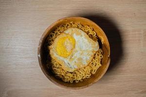 Fried Noodles and Sunny-Side Up Egg on a Wooden Bowl photo