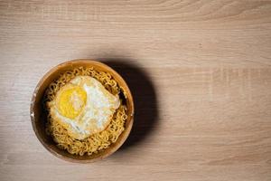 Fried Noodles and Sunny-Side Up Egg on a Wooden Bowl photo